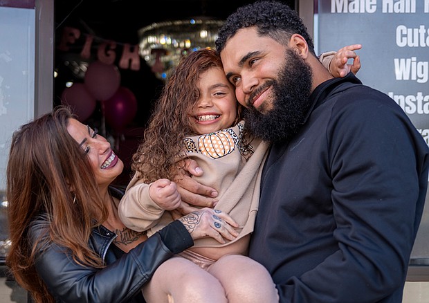 Myla poses with her parents, Kristen Lux and James Freeman, following her confidence-restoring makeover at Bombshell Wigs Galore in Midlothian. The event was held in recognition of Cancer Awareness Month.