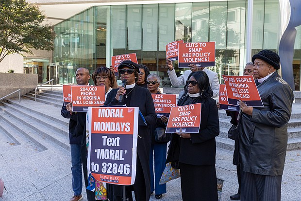 The Rev. Dr. Tonya Pass, pastor of Zion Chester AME Zion Church, is seen outside the offices of U.S. Sens. Tim Kaine and Mark Warner at 919 E. Main St. in Richmond as part of a coordinated, nonviolent mass prayer action held at congressional offices across the country. To her left is the Rev. Dr. Patricia Crawley-Ricks and to her far left is the Rev. Billy Cook, an Army veteran. To her far right is the Rev. Alma Coles Charles, pastor of St. Paul AME Zion Church.