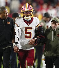 Washington Commanders quarterback Jayden Daniels (5) is helped off
the field after injuring his arm on Sunday in the second half of an NFL
football game against the Seattle Seahawks in Landover, Md.