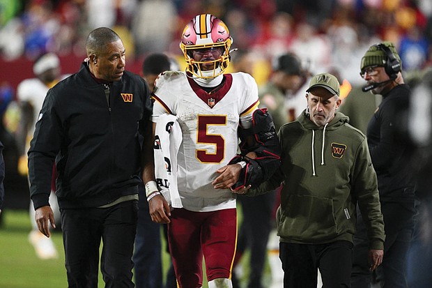 Washington Commanders quarterback Jayden Daniels (5) is helped off
the field after injuring his arm on Sunday in the second half of an NFL
football game against the Seattle Seahawks in Landover, Md.