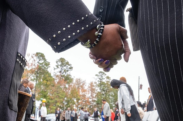 Groundbreaking ceremony commemorates Brown Grove School-The Brown Grove School Memorial Committee held a groundbreaking ceremony Oct. 26 for a new memorial across from Brown Grove Baptist Church in Ashland. The memorial honors the historic Brown Grove School, a two-room schoolhouse built in 1925 that educated African American children in grades 1–7 until it was destroyed by fire in 1942. The school served as a center of learning, pride, and resilience for the Brown Grove community. Attendees hold hands during the groundbreaking ceremony for the Brown Grove School Memorial,
designed in part by civil engineer Fyiad Constantine to symbolize the original two-room schoolhouse.(Sandra Sellars/Richmond Free Press)