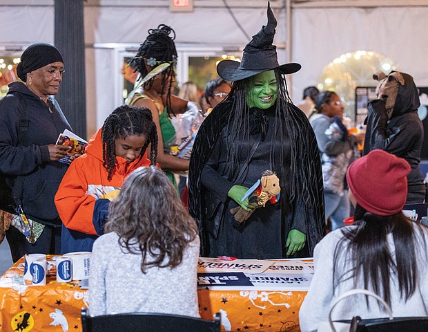 Tricks, treats and togetherness-Families flocked to the Science Museum of Virginia on Halloween for U.S. Rep. Jennifer McClellan’s annual Community Harvest Festival. U.S. Rep. Jennifer McClellan, dressed as the
Wicked Witch, greets families during her annual Community Harvest Festival on Halloween. The event, held Friday evening, offered Richmond-area children a safe space to trick-or-treat, enjoy museum exhibits and connect with community resources. Guests explored hands-on experiences in the museum’s Speed, Boost and The Power of Poison exhibits, along with its Animal, Art and Eco Labs. Halloween laser shows and live science demos added to the night’s festivities. (Julianne Tripp Hillian/Richmond Free Press)