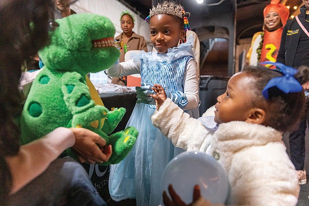 Tricks, treats and togetherness-Families flocked to the Science Museum of Virginia on Halloween for U.S. Rep. Jennifer McClellan’s annual Community Harvest Festival. Aniyah Ruffin, 5, and her sister Miciyah Ruffin, 2,
learn about healthy dental practices from Virginia
Commonwealth University dental students. The event, held Friday evening, offered Richmond-area children a safe space to trick-or-treat, enjoy museum exhibits and connect with community resources. Guests explored hands-on experiences in the museum’s Speed, Boost and The Power of Poison exhibits, along with its Animal, Art and Eco Labs. Halloween laser shows and live science demos added to the night’s festivities. (Julianne Tripp Hillian/Richmond Free Press)