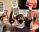Feagin Hardy, a community activist with Sunrise Movement Richmond, holds a sign with other activists at the Richmond Public Schools board meeting Tuesday, Nov. 11 in support of RPS workers and urging the board to reject proposed changes to the collective bargaining resolution.