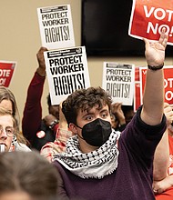 Feagin Hardy, a community activist with Sunrise Movement Richmond, holds a sign with other activists at the Richmond Public Schools board meeting Tuesday, Nov. 11 in support of RPS workers and urging the board to reject proposed changes to the collective bargaining resolution.
