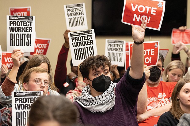 Feagin Hardy, a community activist with Sunrise Movement Richmond, holds a sign with other activists at the Richmond Public Schools board meeting Tuesday, Nov. 11 in support of RPS workers and urging the board to reject proposed changes to the collective bargaining resolution.
