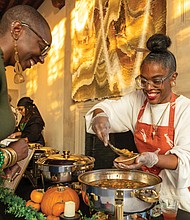 Museum makes way for fashion, food and culture-The Afro-Vegan Social at the Branch Museum of Design on Sunday, Nov. 9, brought together food, fashion and culture. Organized by For the Fem in You, the event highlighted healthy food access while celebrating futuristic African culture and style. Guests enjoyed a set from DJ Chey Butta + Ease, a fashion show featuring multiple designers, a pop-up shop, and vegan tastings from local chefs and restaurants. Shayola Binta serves vegan pumpkin stew to Ariane McKeller. (Julianne Tripp Hillian)