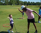A First Tee participant shares a high-five with a younger student after a lesson on the golf course. The chapter recently received the Barbara A. Douglas and Dr. William J. Powell Community Award for its work expanding access to golf and character education for underserved youth.