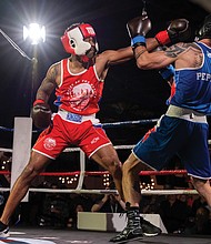 Police, firefighters duke it out for charity-Keivon Henderson of the Richmond City Firefighters, fighting out of the red corner, goes
glove to glove with Richmond Police’s Duane Peppel in the blue. Richmond City firefighters and police officers traded gloves for a good cause during River City Fight Night: Red Fight & Blue at River City Roll on Nov. 5. The charity boxing event raised funds for the Children’s Hospital Foundation, selected by the Fire Department, and the American Kidney Fund, chosen by the Police Department. (Julianne Tripp Hillian/Richmond Free Press)