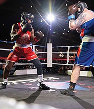 Police, firefighters duke it out for charity-Mo’Reese Moore, representing Richmond firefighters, squares off against Patrick Ripley of Richmond police. Richmond City firefighters and police officers traded gloves for a good cause during River City Fight Night: Red Fight & Blue at River City Roll on Nov. 5. The charity boxing event raised funds for the Children’s Hospital Foundation, selected by the Fire Department, and the American Kidney Fund, chosen by the Police Department. (Julianne Tripp Hillian/Richmond Free Press)