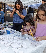 Neighborhood pride shines at Brookland Park Fest-Brookland Park Fest filled the boulevard with music, art and food as residents and visitors gathered Sunday, Nov. 9 for the annual community celebration. The free event, organized by the Brookland Park Business Association, showcased local businesses, artists and food vendors, along with musical performances, family activities and special events hosted by shops along Brookland Park Boulevard between Fendall and North avenues. Neethi Jois (left) and sisters Riley and Evelyn Duong create painted
magnets at the Hand Thrown pottery tent. (Julianne Tripp Hillian)