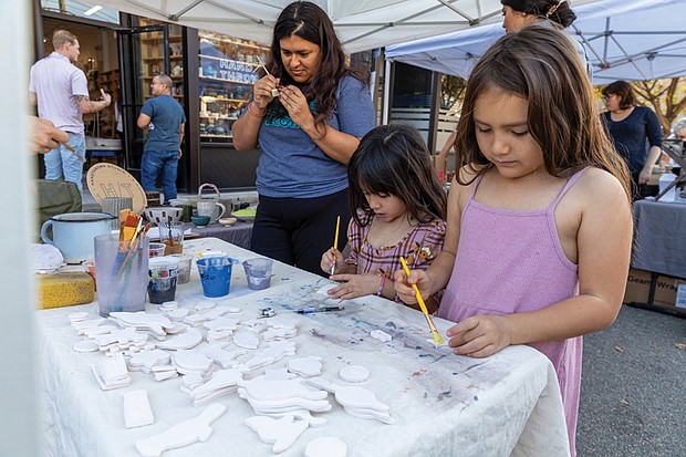 Neighborhood pride shines at Brookland Park Fest-Brookland Park Fest filled the boulevard with music, art and food as residents and visitors gathered Sunday, Nov. 9 for the annual community celebration. The free event, organized by the Brookland Park Business Association, showcased local businesses, artists and food vendors, along with musical performances, family activities and special events hosted by shops along Brookland Park Boulevard between Fendall and North avenues. Neethi Jois (left) and sisters Riley and Evelyn Duong create painted
magnets at the Hand Thrown pottery tent. (Julianne Tripp Hillian)