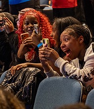 ‘Giants’ excitement-Alicia Keys and Swizz Beatz were welcomed by cheering Richmond-area high school and college students during a pep rally for the “Giants” exhibition at the Virginia Museum of Fine Arts on Wednesday, Nov. 19. The couple were greeted to the stage by the All-City RPS Drum Line and answered questions about their careers as musical artists. Na’zjah Carter, 11th grade; Jazial Fitzgerald, 10th grade; and My’aria Griffith, 9th grade, cheer as Alicia Keys and Swizz Beatz walk on stage at Cheek Theater at the Virginia Museum of Fine Arts.(Julianne Tripp Hillian/Richmond Free Press)