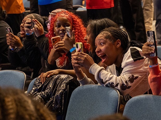 ‘Giants’ excitement-Alicia Keys and Swizz Beatz were welcomed by cheering Richmond-area high school and college students during a pep rally for the “Giants” exhibition at the Virginia Museum of Fine Arts on Wednesday, Nov. 19. The couple were greeted to the stage by the All-City RPS Drum Line and answered questions about their careers as musical artists. Na’zjah Carter, 11th grade; Jazial Fitzgerald, 10th grade; and My’aria Griffith, 9th grade, cheer as Alicia Keys and Swizz Beatz walk on stage at Cheek Theater at the Virginia Museum of Fine Arts.(Julianne Tripp Hillian/Richmond Free Press)