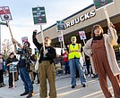 Kat Glynn and Beck Whittenton, Starbucks baristas, Olivia Geho with the
Virginia Education Association and Dustin Bixler, a Starbucks barista, cheer passing cars during a “Red Cup Day” rally Nov. 13 outside the 2309 W. Broad St. Starbucks to protest what they describe as the company’s union busting and its failure to reach a union contract.