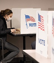 A voter casts a ballot at the Fairfax County Government Center in 2020.
