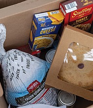 Hands and hearts at work as families receive holiday meals-Thanksgiving meal boxes from Bethlehem Baptist Church are filled with turkeys and groceries for local families in need. (photo by Julianne Tripp Hillian/Richmond Free Press)