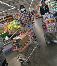 Hands and hearts at work as families receive holiday meal-Members of the Bethlehem Baptist Church men’s fellowship group shop for turkeys and groceries to fill meal boxes.(photo by Sean Taylor)