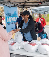 Hands and hearts at work as families receive holiday meals-Families line up at River City Middle School on Richmond’s South Side on Saturday, Nov. 22 for Del. Michael Jones’ seventh annual Turkey Giveaway and Resource Fair, where about 2,000 turkeys and boxes of stuffing were handed out from 9 a.m. to 3 p.m. (photo by Julianne Tripp Hillian/Richmond Free Press)