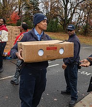Hands and hearts at work as families receive holiday meals-Families line up at River City Middle School on Richmond’s South Side on Saturday, Nov. 22 for Del. Michael Jones’ seventh annual Turkey Giveaway and Resource Fair, where about 2,000 turkeys and boxes of stuffing were handed out from 9 a.m. to 3 p.m. (photo by Julianne Tripp Hillian/Richmnond Free Press)