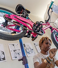 Earning two wheels Richmond Public Schools teamed up with Rag & Bones on Nov. 24 to refurbish up to 50 bikes for students who improve their attendance — with some two-wheelers rolling out to recipients as early as next week. The attendance incentive program targets students in grades K-12, though organizers expect middle and high schoolers to benefit most since they can ride to school on their own. The school district plans to distribute bikes through the spring and again before summer break. Renee Hill works on the rear wheel and drivetrain of a bicycle. (photo by Julianne Tripp Hillian/Richmond Free Press)