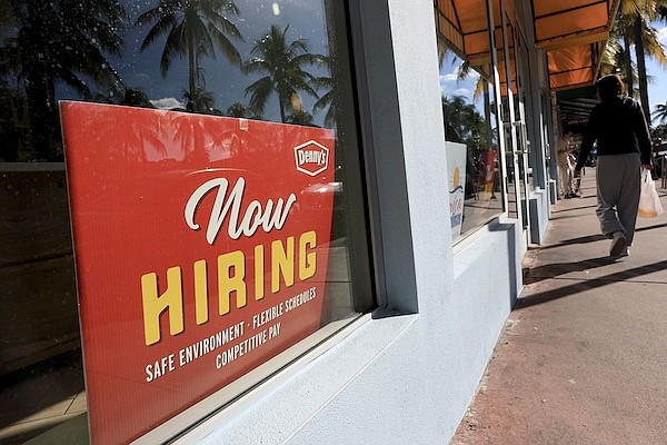 A 'Now Hiring' sign sits in the window of a Denny's restaurant on November 19 in Miami.