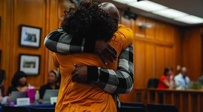 Alumni from John F. Kennedy High School celebrate after the School Board voted to rename Armstrong High School to Armstrong-Kennedy High School.