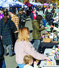 Small Business Saturday brings community, commerce together-Shoppers filled Sheppard Street on Nov. 29 for the Small Business Saturday Market hosted by RVA Galleries between Floyd and Ellwood avenues. The market featured 75 vendors offering everything from ceramics and fine art to spirits and locally made food. Katherine Thompson, a three-time RVA Galleries vendor, talks with a visitor at her booth. (photo by Julianne Tripp Hillian/Richmond Free Press)