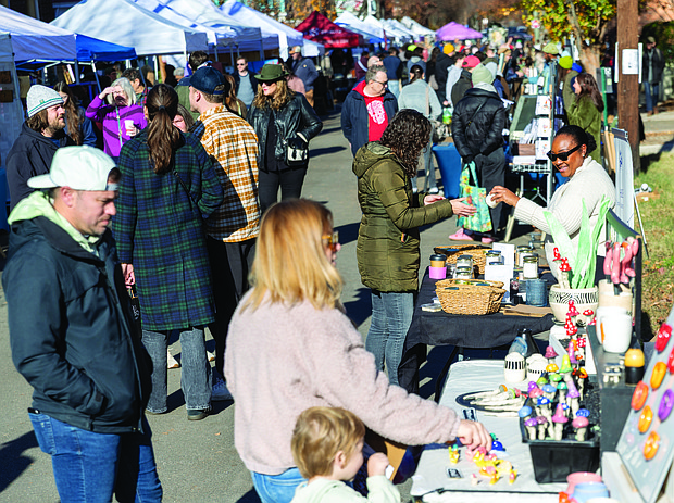 Small Business Saturday brings community, commerce together-Shoppers filled Sheppard Street on Nov. 29 for the Small Business Saturday Market hosted by RVA Galleries between Floyd and Ellwood avenues. The market featured 75 vendors offering everything from ceramics and fine art to spirits and locally made food. Katherine Thompson, a three-time RVA Galleries vendor, talks with a visitor at her booth. (photo by Julianne Tripp Hillian/Richmond Free Press)
