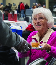A Thanksgiving of service-The Giving Heart marked its 20th annual Thanksgiving Day Feast last Thursday at the Greater Richmond Convention Center, drawing more than 1,000 people to the exhibit hall for a day centered on meals and community connection. Kathy Taylor, one of the many table hosts at the event, selects a slice of sweet potato pie. (photo by Sandra Sellars/Richmond Free Press)
