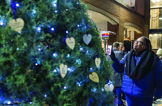 Lighting the way for healing and change-Henrico County’s held its annual Candlelight & Ribbon Tying Ceremony on Tuesday to honor homicide victims. Sponsored by the Henrico County Commonwealth’s Attorney’s Victim/Witness Program, the event featured prayer, remarks from friends and family of the deceased, a memorial board of photographs and a memorial tree where participants placed the names of those they have lost. Early reports show the county has recorded just two homicides through December 2025, down from 22 during the same period last year — a potential 91% decrease if the trend holds through year’s end. Nicole Totten shares the Victims’ Rights memorial tree at Henrico County’s annual Attendees pause at the memorial board displaying photos of loved ones. ceremony as she remembers her niece, Diamond Cox. (Photo by Julianne Tripp Hillian/Richmond Free Press)