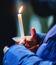 Lighting the way for healing and change-Henrico County’s held its annual Candlelight & Ribbon Tying Ceremony on Tuesday to honor homicide victims. Sponsored by the Henrico County Commonwealth’s Attorney’s Victim/Witness Program, the event featured prayer, remarks from friends and family of the deceased, a memorial board of photographs and a memorial tree where participants placed the names of those they have lost. Early reports show the county has recorded just two homicides through December 2025, down from 22 during the same period last year — a potential 91% decrease if the trend holds through year’s end. An attendee holds a candle during the event, which concluded with an outdoor reception. (Photo by Julianne Tripp Hillian/Richmond Free Press)