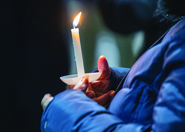 Lighting the way for healing and change-Henrico County’s held its annual Candlelight & Ribbon Tying Ceremony on Tuesday to honor homicide victims. Sponsored by the Henrico County Commonwealth’s Attorney’s Victim/Witness Program, the event featured prayer, remarks from friends and family of the deceased, a memorial board of photographs and a memorial tree where participants placed the names of those they have lost. Early reports show the county has recorded just two homicides through December 2025, down from 22 during the same period last year — a potential 91% decrease if the trend holds through year’s end. An attendee holds a candle during the event, which concluded with an outdoor reception. (Photo by Julianne Tripp Hillian/Richmond Free Press)