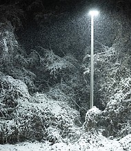 Cityscape Slices of life and scenes in Richmond-A street lamp casts a warm glow on snow-covered trees off Interstate 95 during Richmond’s second round of winter weather on Monday, Dec. 8. (photo by Julianne Tripp Hillian/Richmond Free Press)