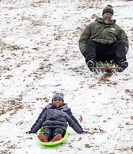First snow, first fun-Eric Smith, 46, goes sledding with his grandson, Zakai Jones, 6, at Forest Hill Park. (photo by Julianne Tripp Hillian/Richmond Free Press)