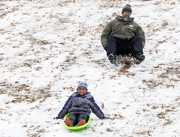 First snow, first fun-Eric Smith, 46, goes sledding with his grandson, Zakai Jones, 6, at Forest Hill Park. (photo by Julianne Tripp Hillian/Richmond Free Press)