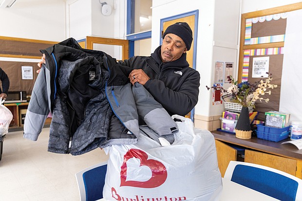 Community efforts bring warmth to students-Community groups and organizations stepped in last week to help Richmond students stay warm as colder weather sets in, with two separate coat distribution effort reaching hundreds of children. Chuck Bradby, president of Club 533, unpacks new coats for students at Carver Elementary School on Dec. 12 as part of the group’s midyear coat drive. Across the city, members of Club 533 organized a separate coat drive to support students at Carver Elementary School. The historic Jackson Ward-based group collected
more than 100 coats, with an additional 20 donated by
Brothers and Sisters Combined Professional Firefighters Inc.
The coats were delivered Dec. 12 and will be distributed
to students Friday. (photo by Julianne Tripp Hillian/Richmond Free Press)