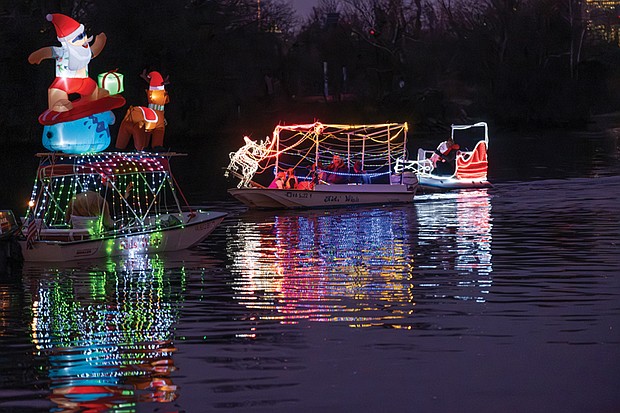Holiday magic lights up the James River-
The Richmond Boat Parade of Lights returned Saturday, Dec. 13 starting at 5 p.m. from Rocketts Landing and cruising downriver to Osborne
Park & Boat Landing near The Lilly Pad restaurant around 7 p.m. Hundreds watched along the river and at popular viewing spots like Libby Hill
and Osborne Park. Several brightly lit boats make their way down the James River, their colorful lights reflecting in the water. Boats decorated
with holiday lights cruise down the James River, including one carrying a surfing Santa Claus. (photo by Sandra Sellars/Richmond Free Press)