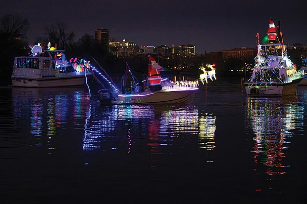 Holiday magic lights up the James River-
The Richmond Boat Parade of Lights returned Saturday, Dec. 13 starting at 5 p.m. from Rocketts Landing and cruising downriver to Osborne
Park & Boat Landing near The Lilly Pad restaurant around 7 p.m. Hundreds watched along the river and at popular viewing spots like Libby Hill
and Osborne Park. Several brightly lit boats make their way down the James River, their colorful lights reflecting in the water. Boats decorated
with holiday lights cruise down the James River, including one carrying a surfing Santa Claus. (photo by Sandra Sellars/Richmond Free Press)