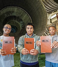 Houston ISD students pose in front of the Saturn V rocket at the George W.S. Abbey Rocket Park during an October tour, holding journals provided by the Cactus Jack Foundation. (Photo Courtesy of Space Center Houston).
