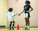 Timani Harris greets a young participant during her basketball clinic at Trinity Family Life Center in Richmond on Saturday.