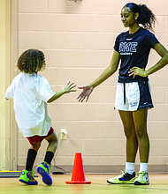 Timani Harris greets a young participant during her basketball clinic at Trinity Family Life Center in Richmond on Saturday.