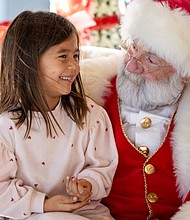 Families meet Santa at American Civil War Museum-Families gathered at the American Civil War Museum on Saturday, Dec. 20, for a holiday celebration featuring a visit from Santa, arts and crafts for children, and a chance to take care of last-minute holiday requests. Ana Gomez, 5, asks Santa for a stuffed animal during his visit. (photo by Julianne Tripp Hillian/Richmond Free Press)
