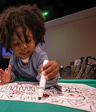 Honoring heritage with community and celebration-AKahmen O’Neal, 2,
colors a creation at Watoto Kwanzaa, where children make art and learn about the Kwanzaa celebration. (photo by Sandra Sellars/Richmond Free Press)