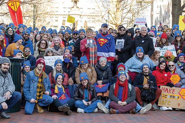 Voices raised for peace and change on MLK Day-Richmonders marked Martin Luther King Jr. Day with a series of events, including Virginia Union University’s 47th annual community leaders breakfast, a candlelight vigil for peace outside the Virginia War Memorial, and Lobby Day rallies for gun violence prevention and gun rights at Capitol Square. Vigil and Advocacy Day for gun violence prevention-Advocates for gun violence prevention gathered at the Bell Tower in Capitol Square on Lobby Day, Jan. 19 for the 34th annual Virginia Vigil and Advocacy Day to Prevent Gun Violence, honoring Dr. Martin Luther King Jr. through advocacy. This event came hours after gun rights lobbyists filled the same space arguing for fewer
gun protections and more gun rights. Many in attendance remembered Adam Turck, who was fatally shot in Shockoe Bottom in August, and wore Superman hats and attire in his honor. His parents, Peter and Terry Ann Turck, hold his photo.(photo by Julianne Tripp Hillian/Richmond Free Press)