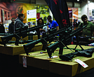 Scoped assault rifles stand on display at a recent gun show in Richmond.
