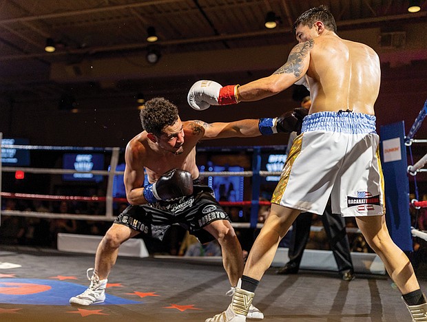 Between the ropes-On Feb. 4, Great American Ranch in Midlothian
hosted a charity boxing event supporting Guardian
of the Gloves. The series will continue monthly through 2026, featuring WBC champions, Olympic medalists, international fighters and local professionals. Andrew Kim, in the white trunks, takes aim at Roberto Cantos. (photo by Julianne Tripp Hillian/Richmond Free Press)