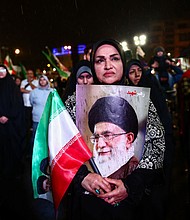 A woman holds a poster of Iran’s late Supreme Leader Ayatollah Ali Khamenei during an anti-US and anti-Israel rally, amid a ceasefire between U.S. and Iran, in Tehran, Iran, on April 19.