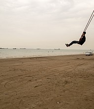 A man swings from a giant rope swing on the beach as ships are anchored near the shoreline on April 22 in Bandar Abbas, Iran. Bandar Abbas is a port city and the capital of Hormozgan Province, along the Persian Gulf and Strait of Hormuz.