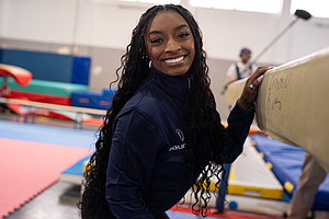 Simone Biles poses for a photo while visiting young gymnasts in Milan, Italy, in February.